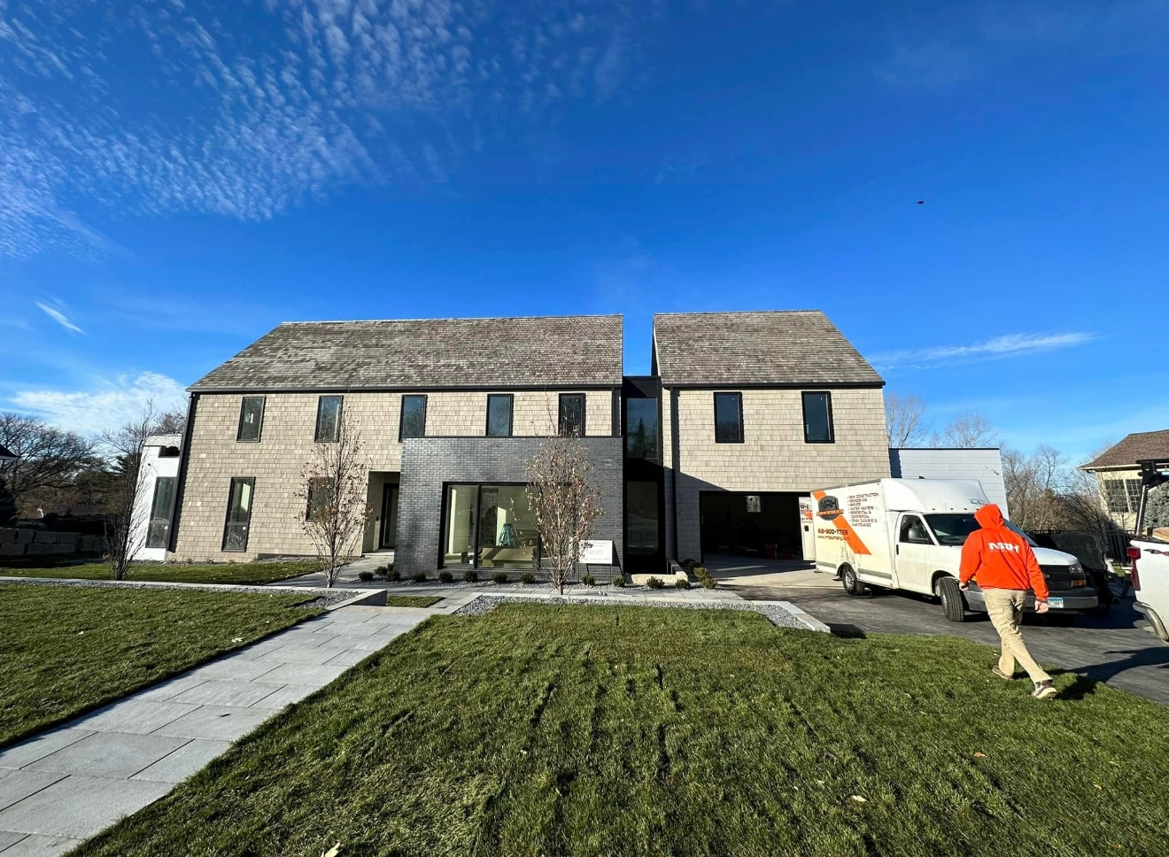 White double vanity in bathroom with two mirrors, sinks, and sconces.