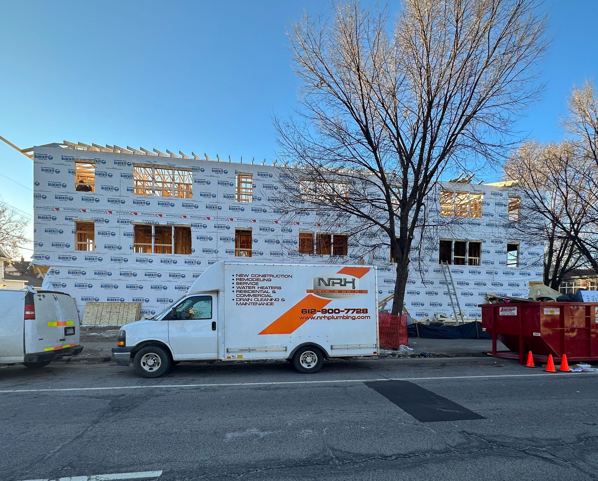 White PVC pipes attached to a concrete ceiling in a construction setting.