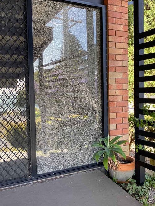 A Brick Building with A Sliding Glass Door and A Potted Plant — Reflect Glass In Tuggerah, NSW