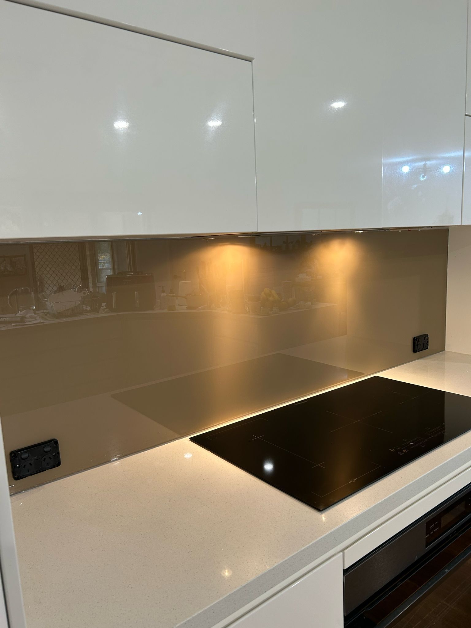 A Kitchen with A Stove Top Oven and A Glass Backsplash — Reflect Glass In Tuggerah, NSW