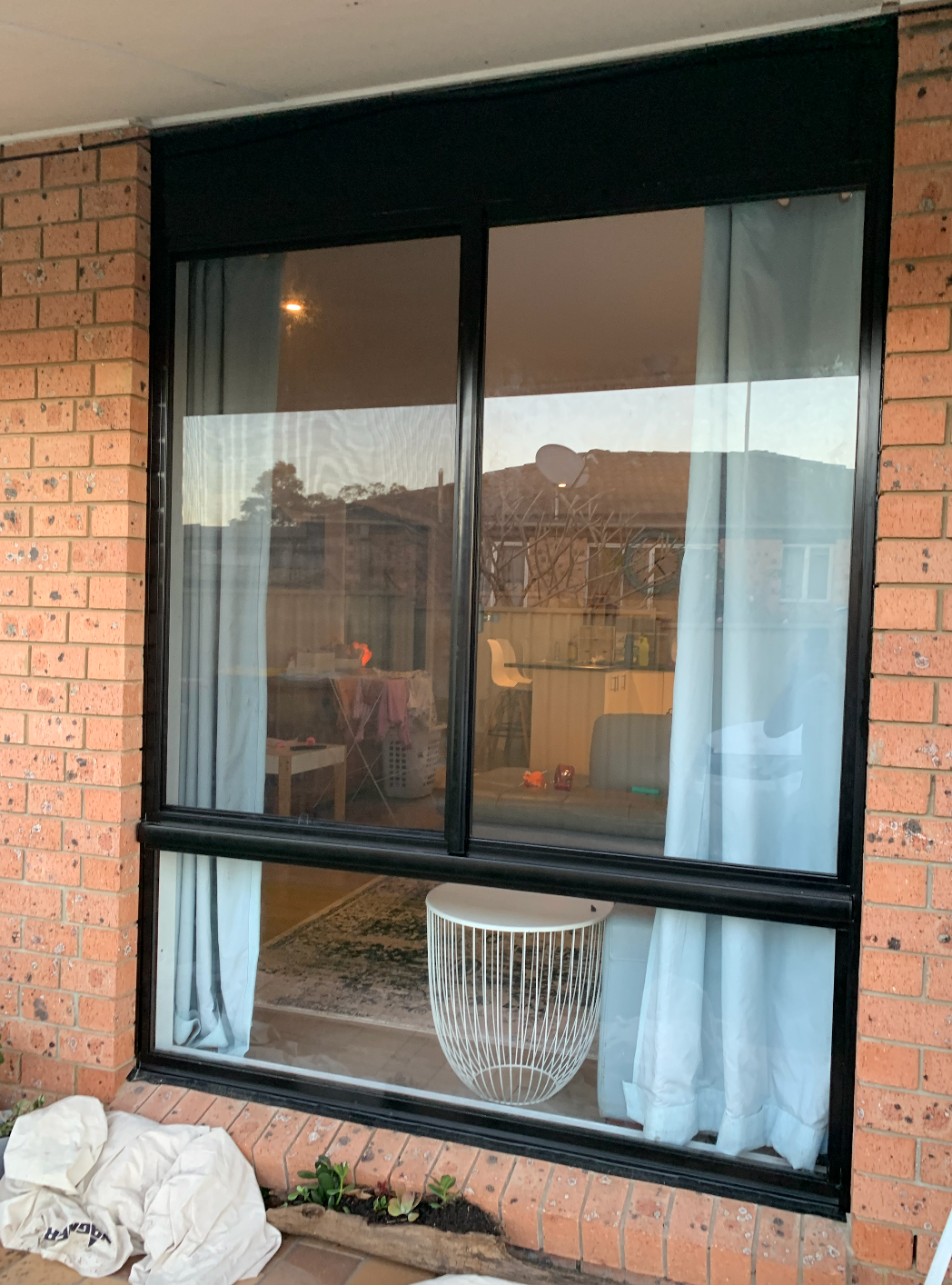 A Large Window in A Brick Building with White Curtains — Reflect Glass In Tuggerah, NSW