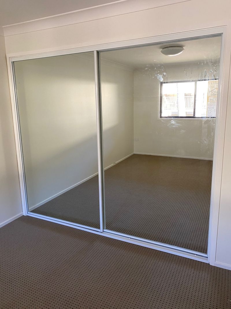 A Bedroom with Sliding Glass Doors and A Large Mirror — Reflect Glass In Tuggerah, NSW