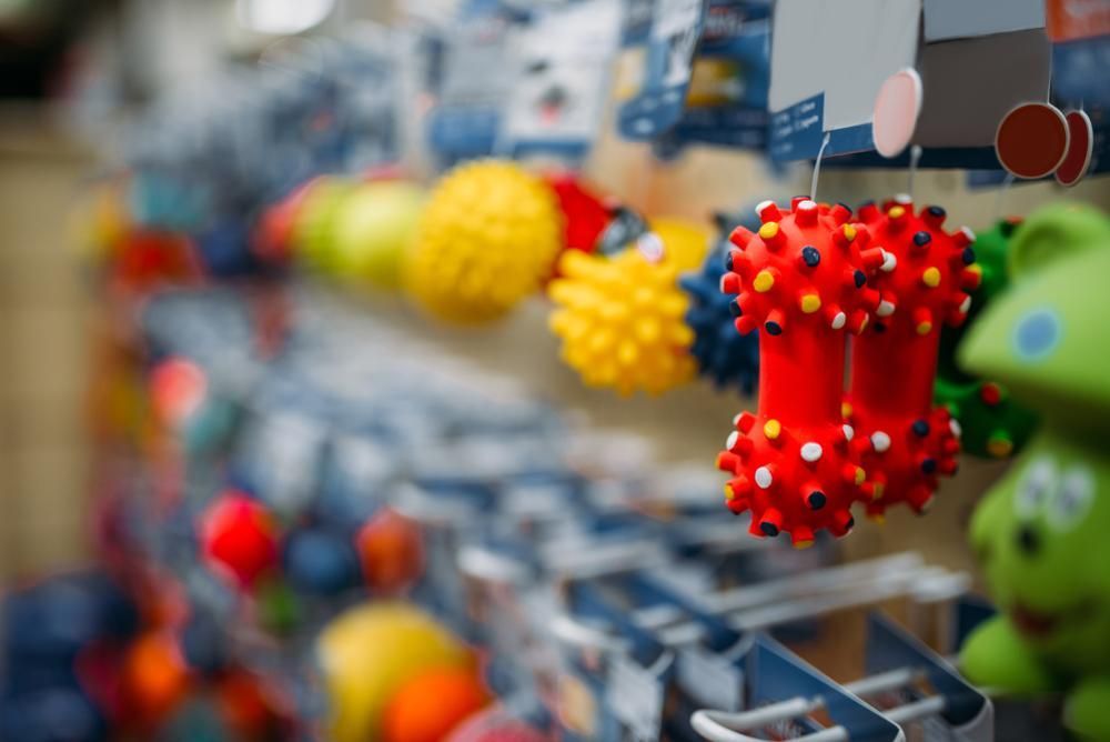 A Bunch of Toys Are Hanging on a Rack in a Store — Fluffy Paws Pet Grooming In Wingham, NSW