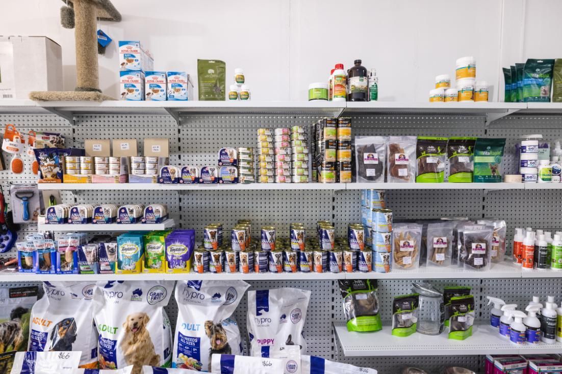 A Shelf Filled With Lots of Dog Food and Other Items in a Pet Store — Fluffy Paws Pet Grooming In Taree, NSW