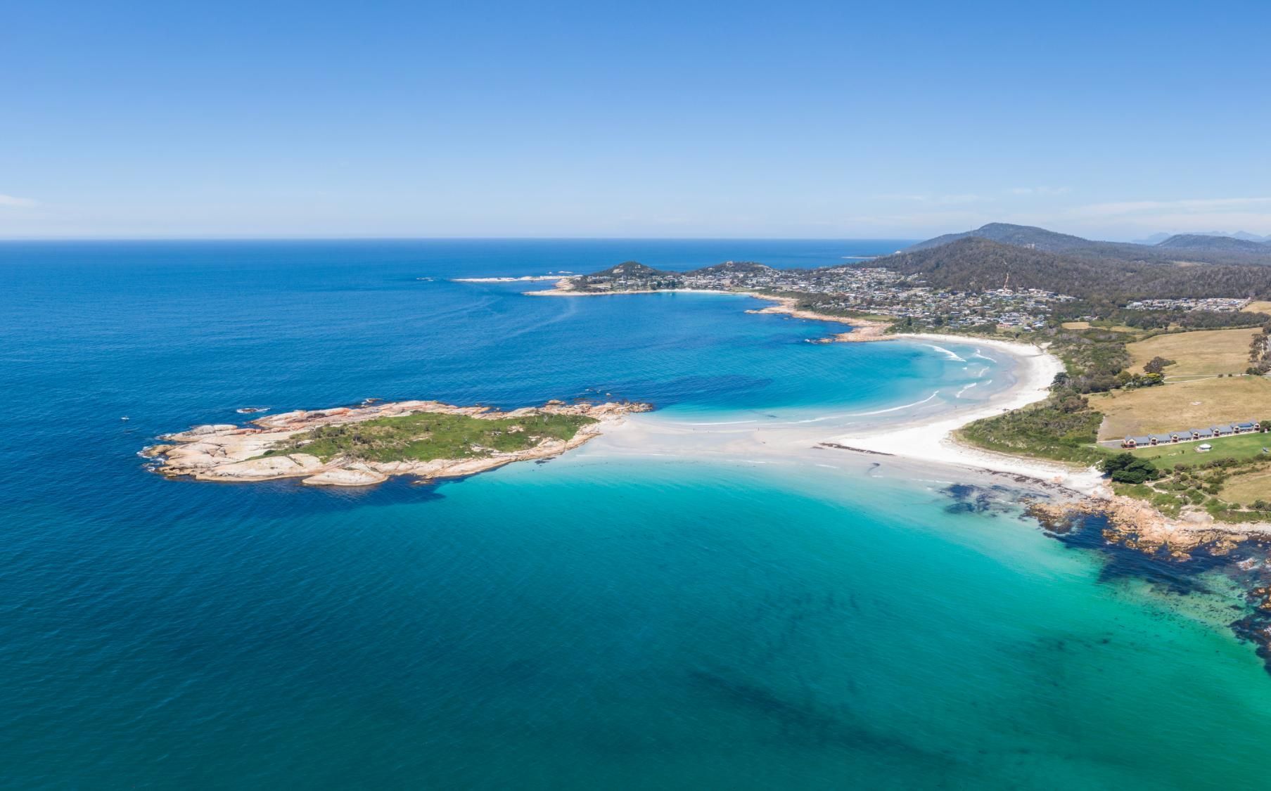 An Aerial View of a Beach With a Small Island in the Middle of the Ocean — Fluffy Paws Pet Grooming In Diamond Beach, NSW