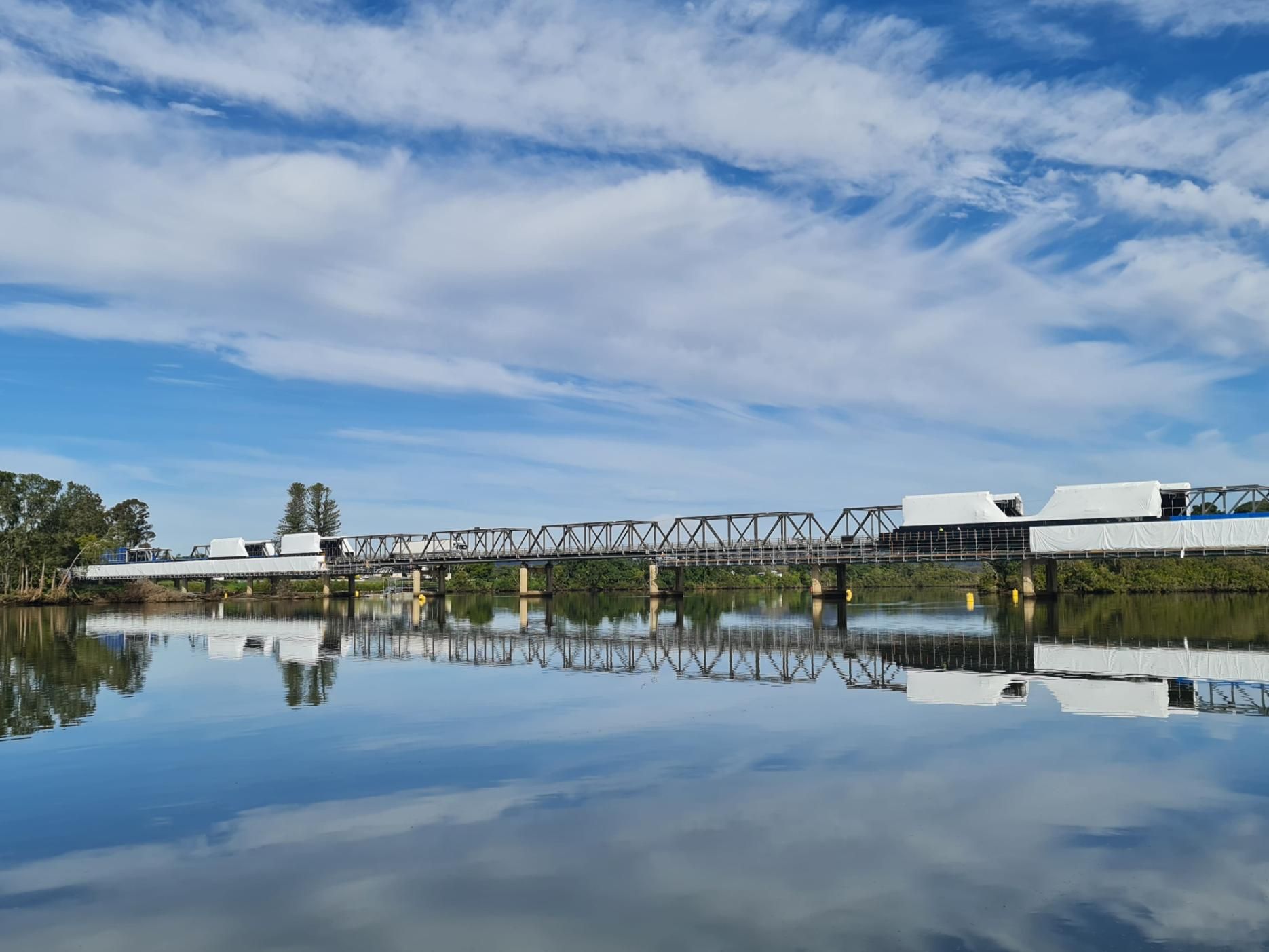 A Bridge Over a Body of Water With a Blue Sky in the Background — Fluffy Paws Pet Grooming In Taree, NSW
