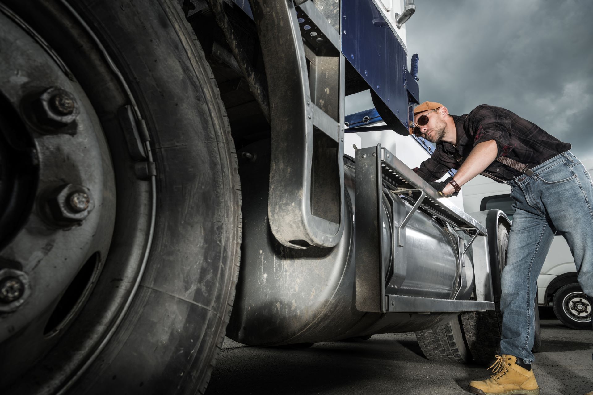 A man is working on the engine of a semi truck.