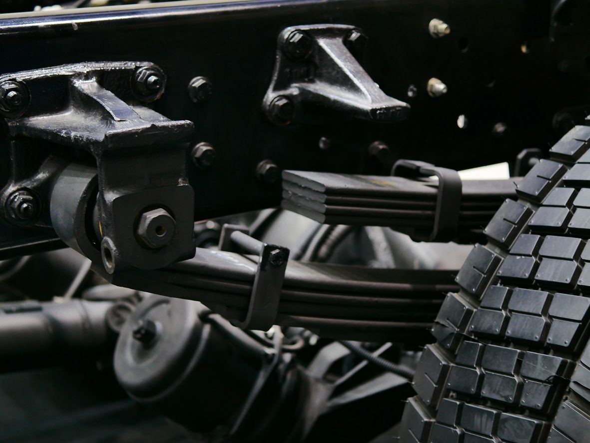 Black leaf springs attached to the chassis of a truck