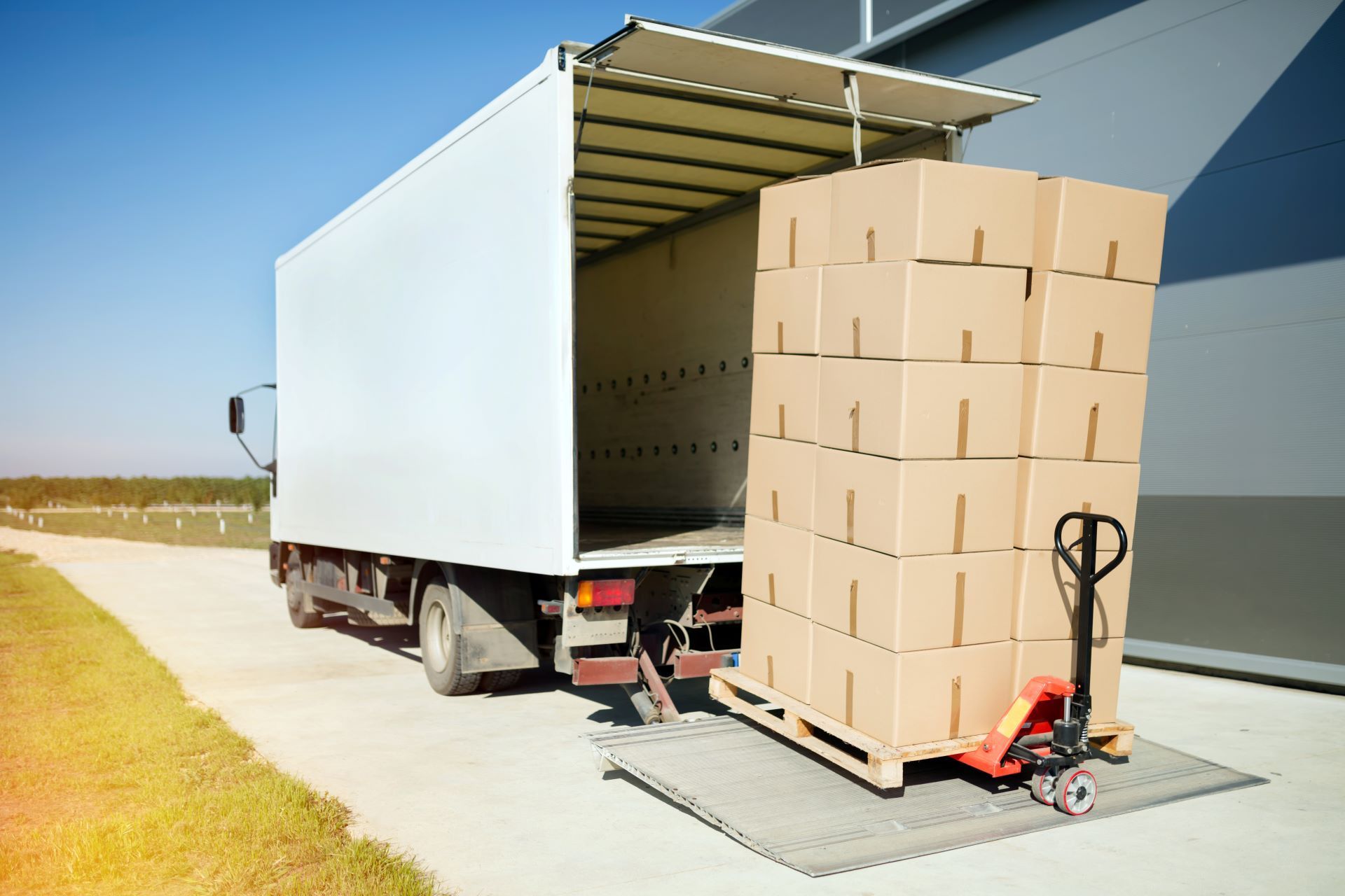 A truck is loading boxes onto a pallet in a warehouse.
