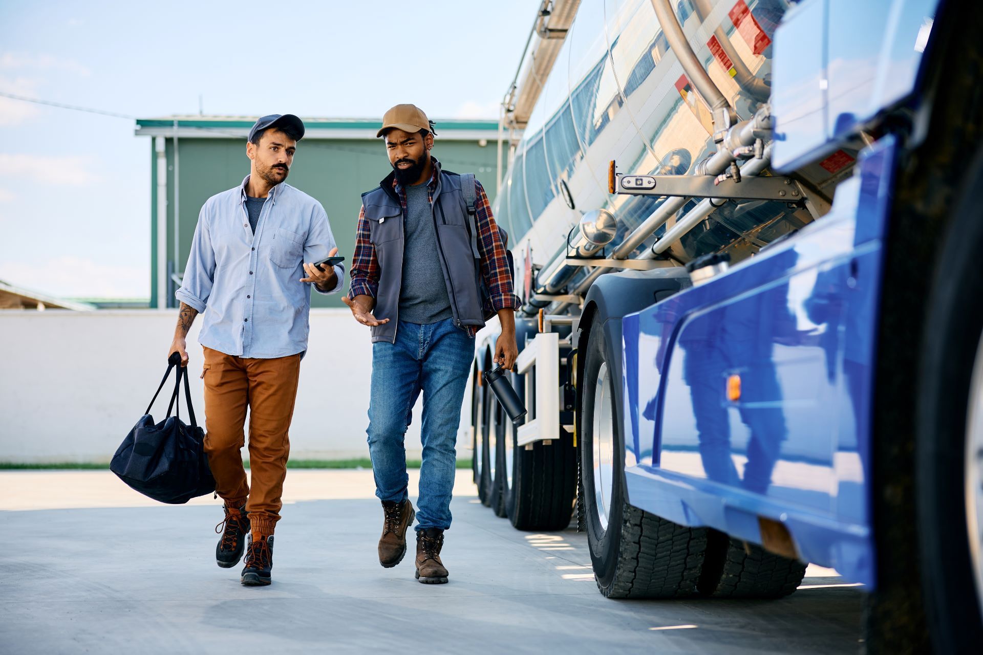 Two men are walking next to a truck in a parking lot.