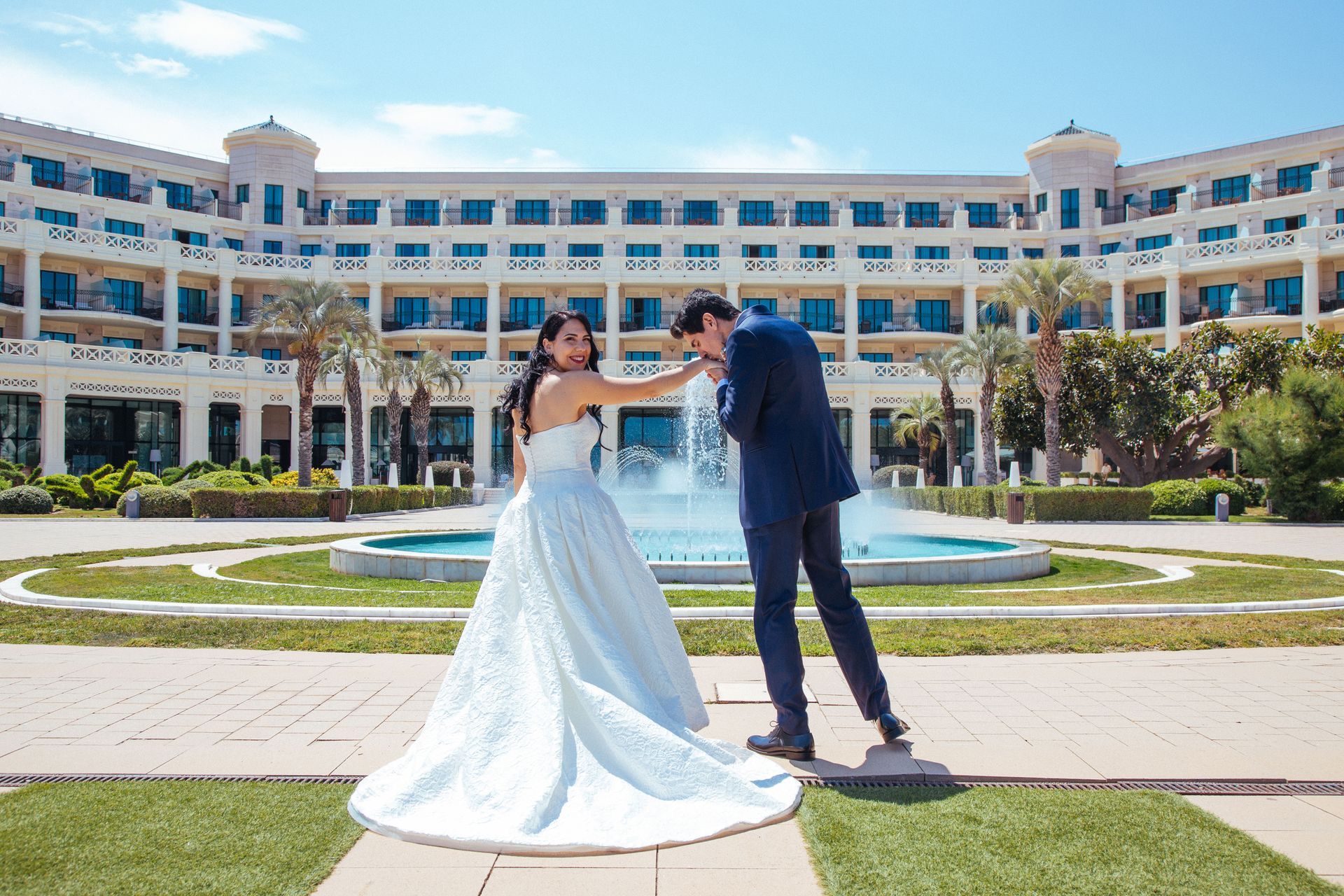 Novio besando mano de novia en el jardín del Hotel Balneario Las Arenas de Valencia, España