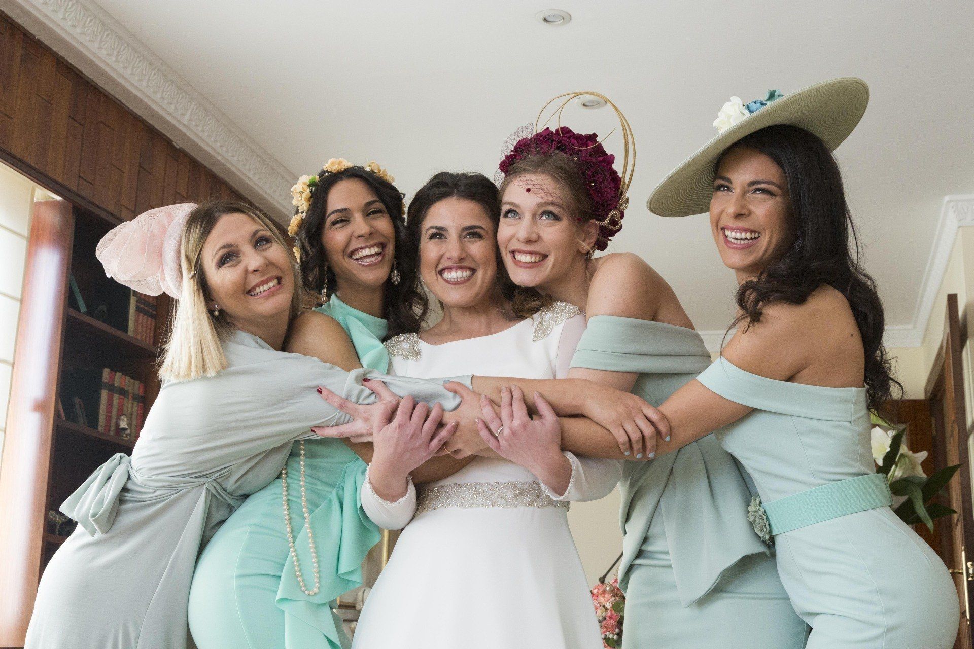 Fotógrafo de bodas en Valencia capturando una emotiva imagen de la novia de boda abrazándose con sus entrañables amigas, en un momento lleno de amor y complicidad en su gran día.