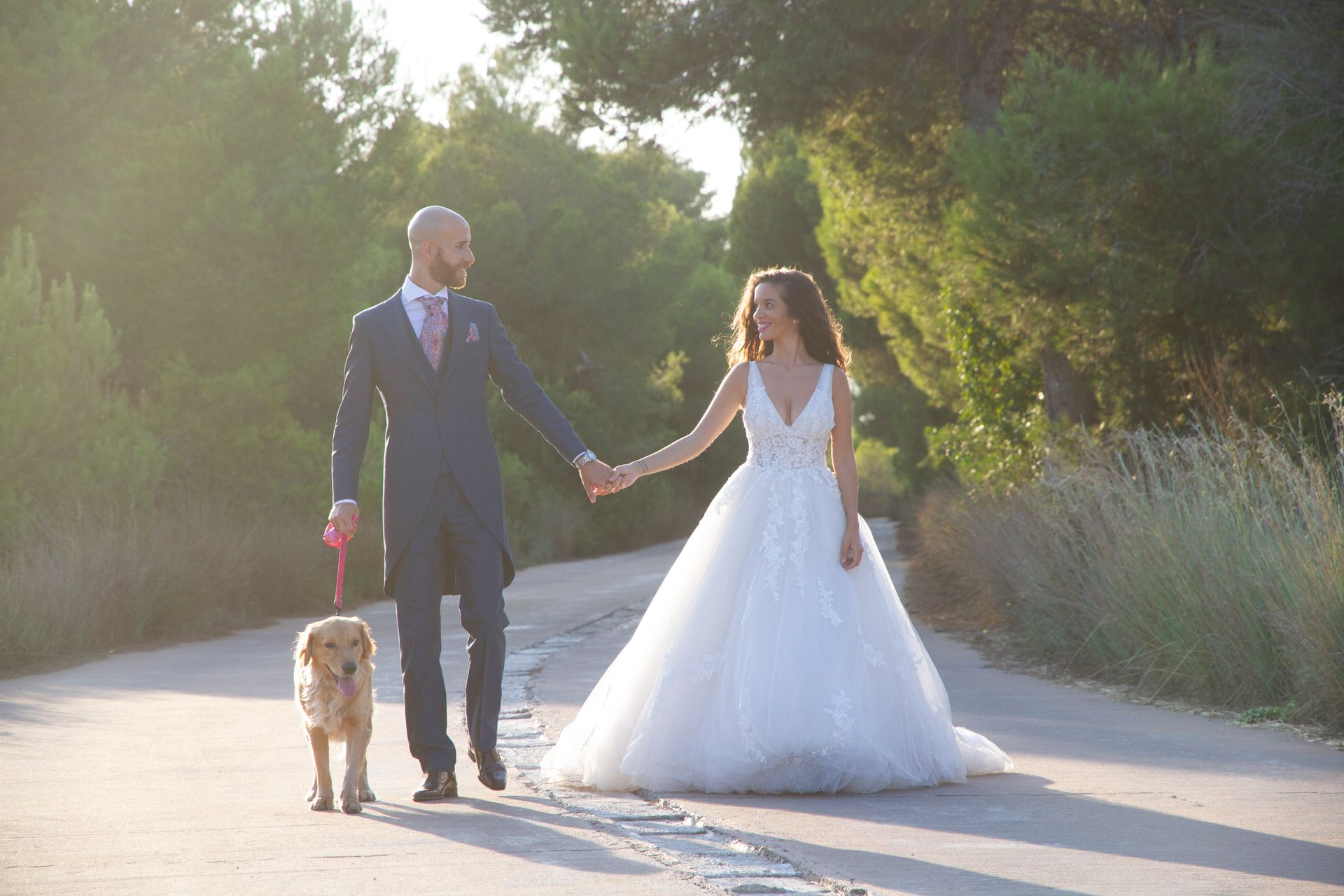 Novios sentados mirándose mientras pasean con su perro en El Saler, Valencia.