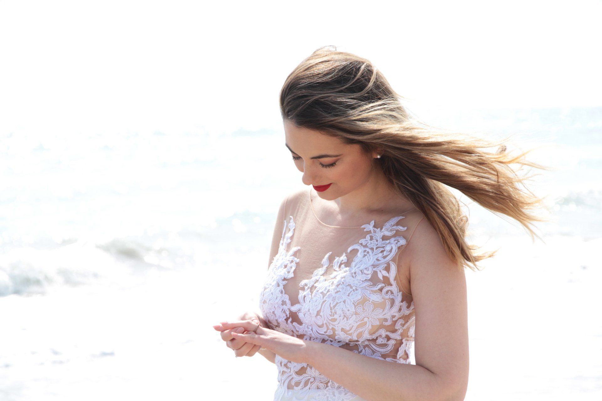 Novia boda en la playa mirándose el anillo. Fotógrafo Valencia