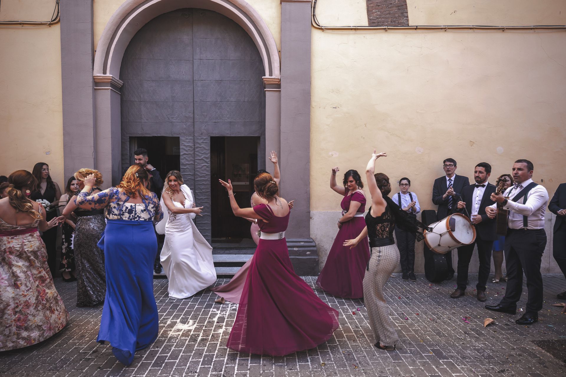 Fotógrafo de bodas en Valencia capturando a la novia bailando a la salida de la iglesia el día de su casamiento.