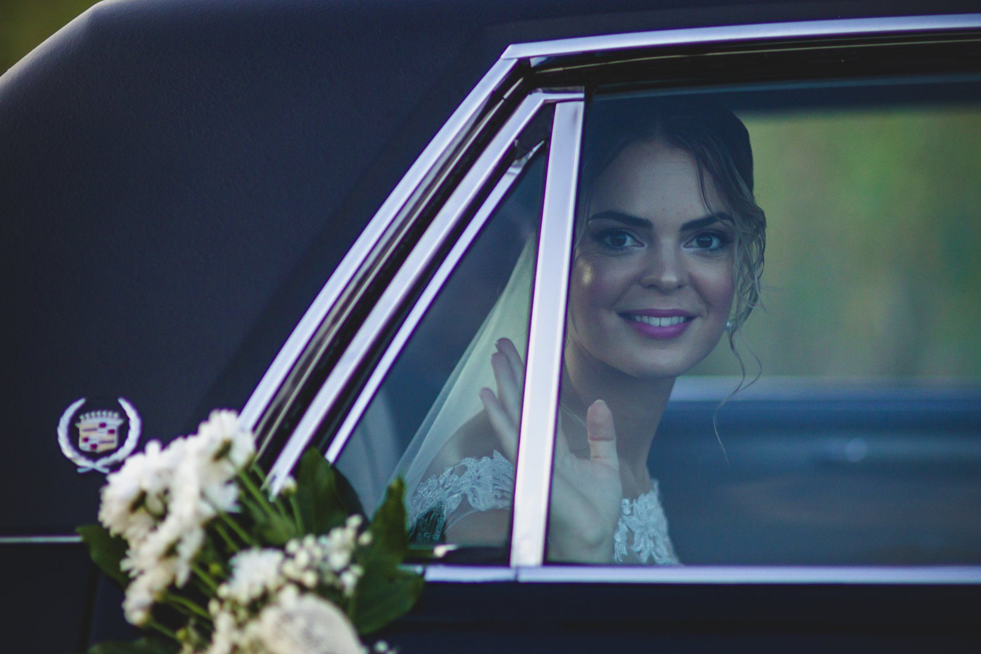 Fotógrafo de bodas en Valencia capturando a la novia boda mirando por la ventana del coche.