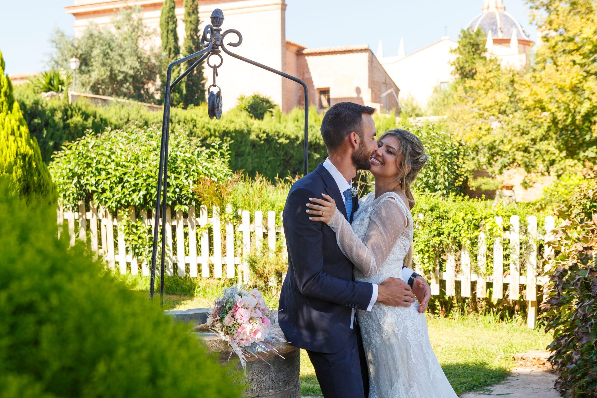 Beso de los recién casados Jessika y Rafael en un Jardín en Valencia. 