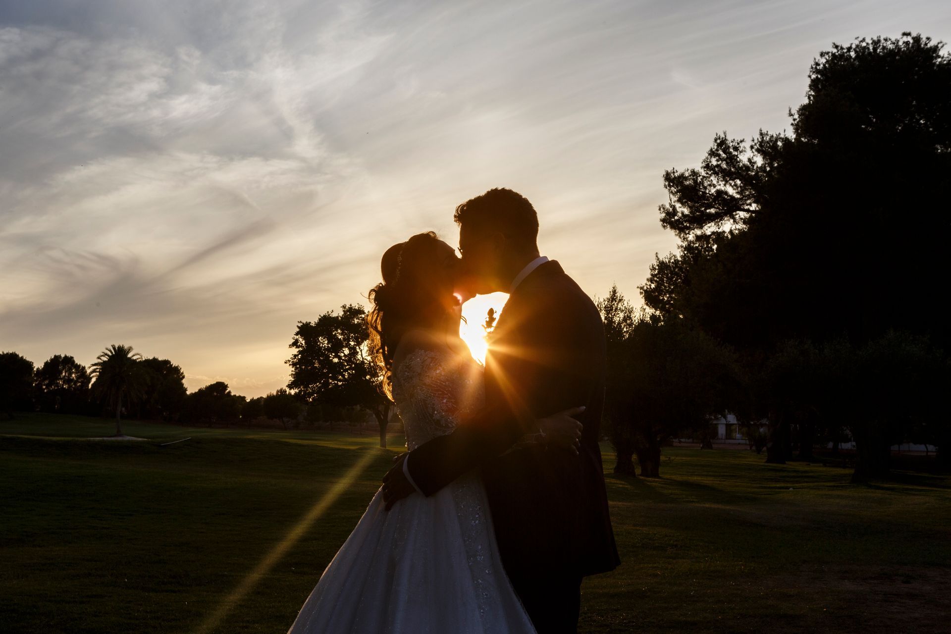Fotógrafo de bodas capturando a los novios besándose al atardecer en el Club de Golf Escorpión, Bétera, Valencia. Fotógrafo Valencia