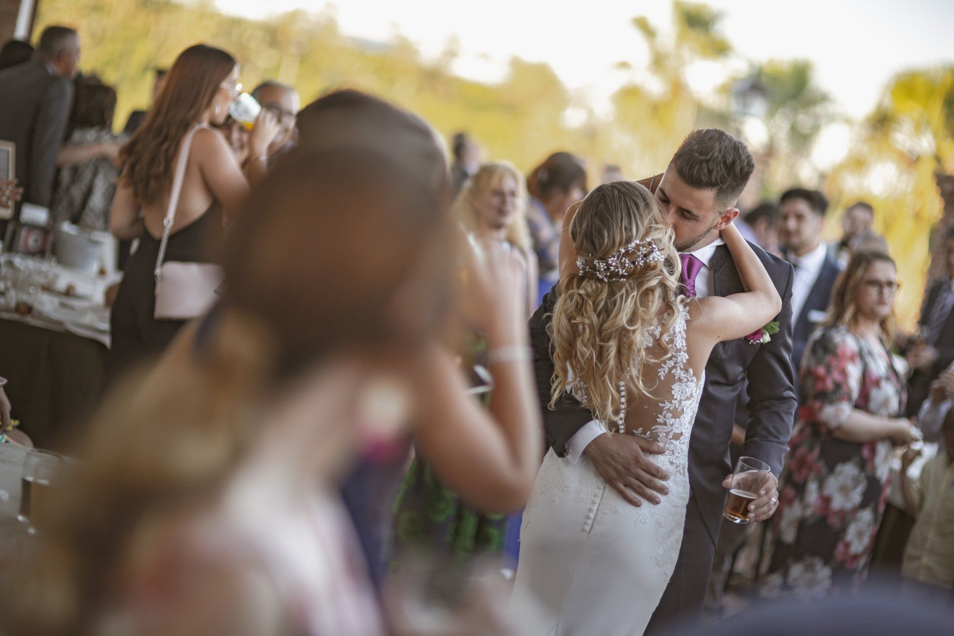 Fotógrafo de bodas en Valencia capturando a los novios besándose en el coctel de su celebración.