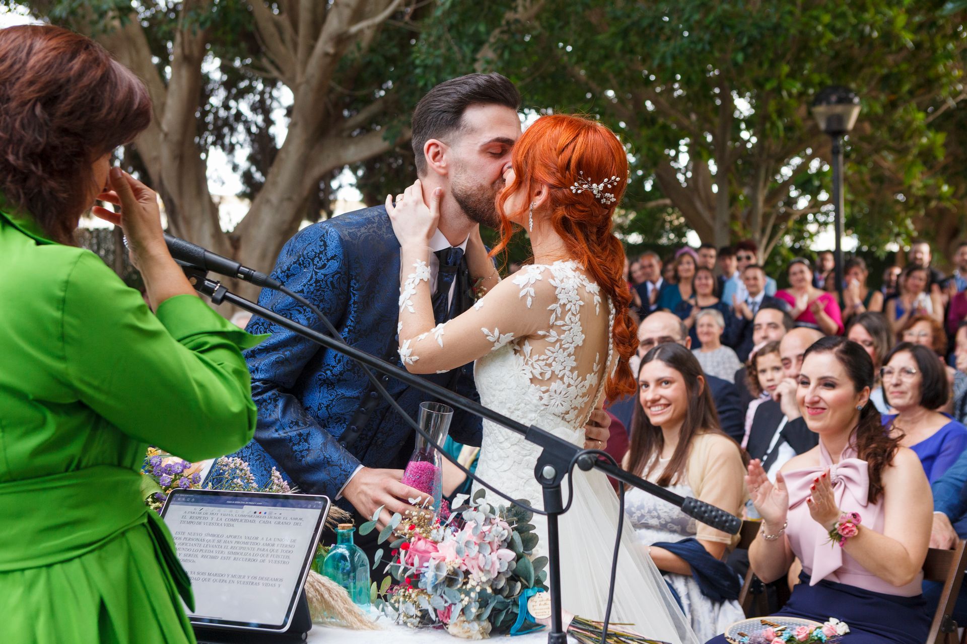 Fotógrafo de bodas capturando a los novios besándose durante la ceremonia de su boda en Castellón, España.