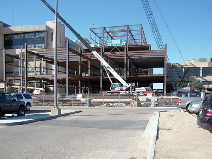 A construction site with cars parked in front of it