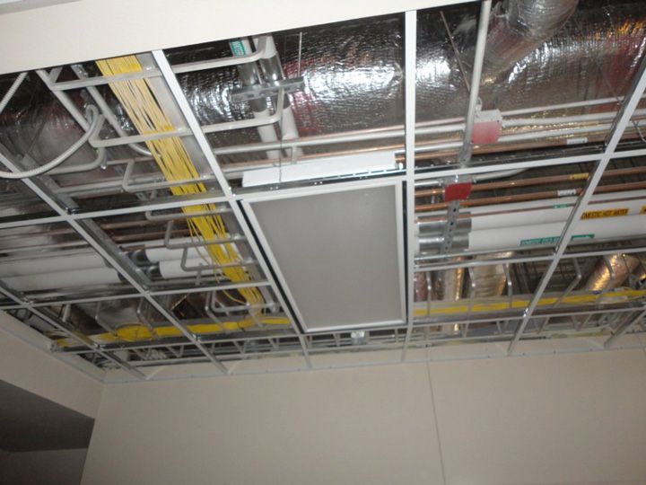 A ceiling with a lot of pipes and wires