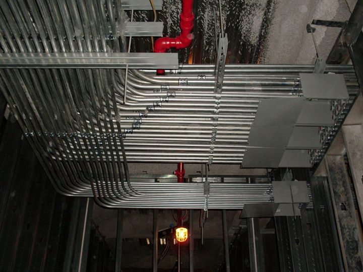 A bunch of metal pipes are hanging from the ceiling