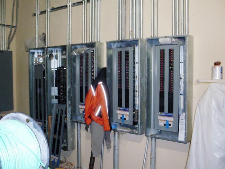 A jacket is hanging on a hook in a room with electrical boxes
