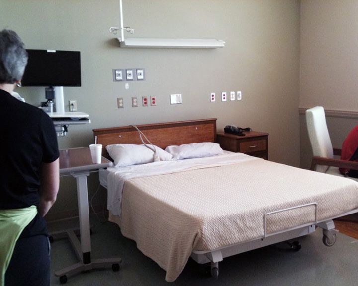 A hospital room with a bed and a computer monitor