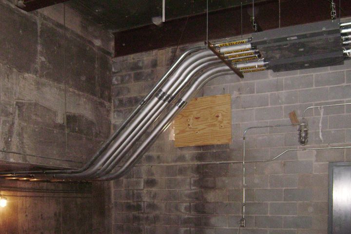 A bunch of pipes are hanging from the ceiling in a room.