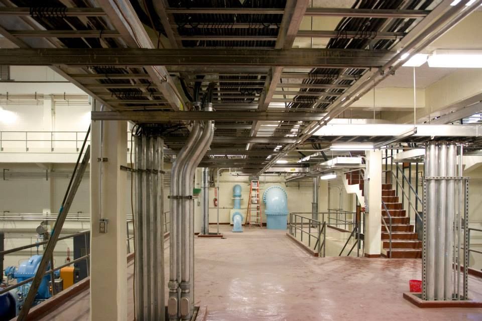 A large room with a lot of pipes and wires hanging from the ceiling.