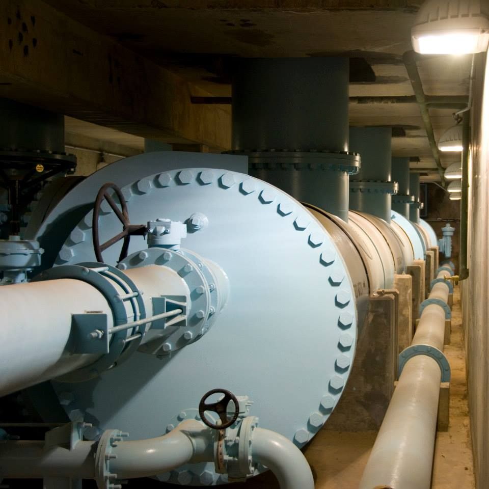 A row of pipes are lined up in a warehouse