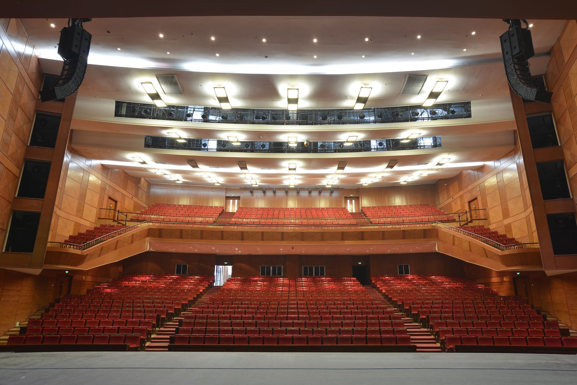 A large auditorium with red seats and a stage