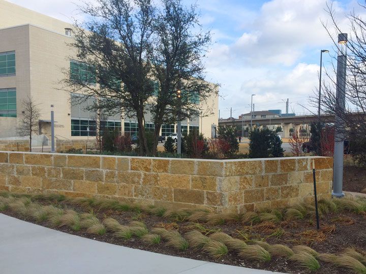 A large building with a stone wall in front of it