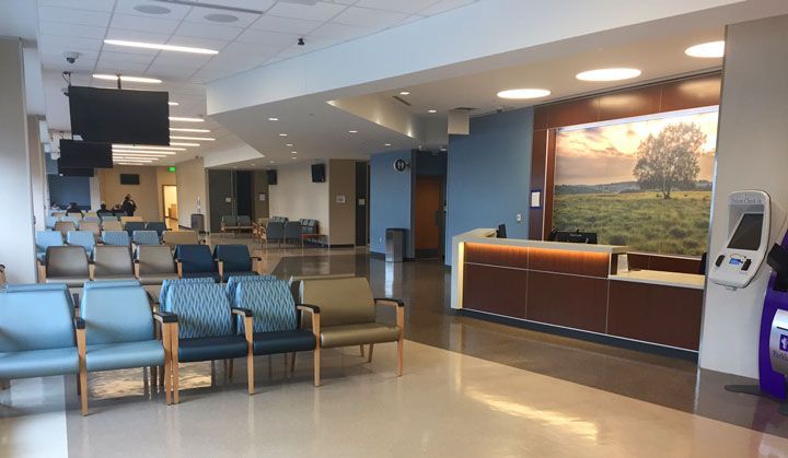 A waiting room with a lot of chairs and a counter
