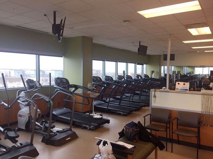A gym with a lot of treadmills and ellipticals
