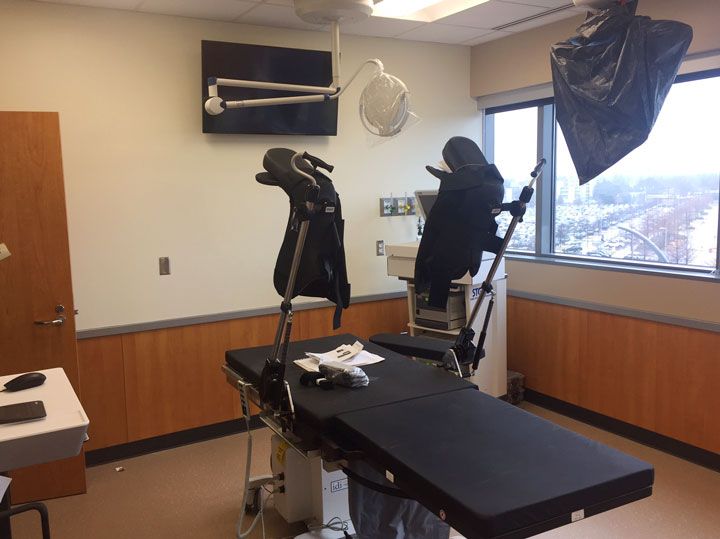 An empty operating room with a black table and chairs