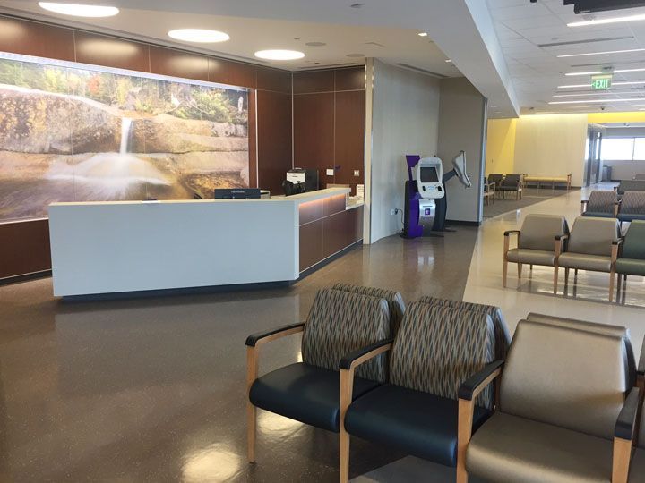 A waiting room with chairs and a counter in a hospital.
