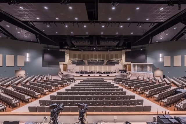 A large auditorium with rows of seats and a stage