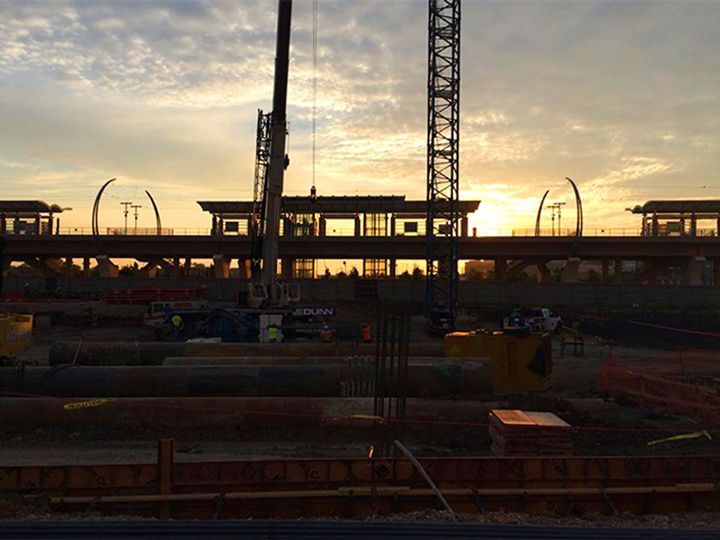 A construction site with a sunset in the background