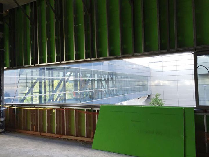 A building under construction with green walls and a large window