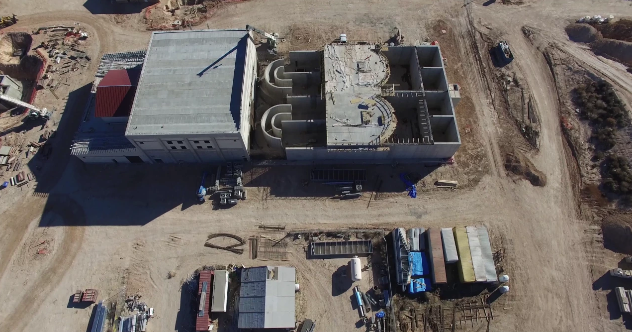 An aerial view of a large building in the middle of a dirt field