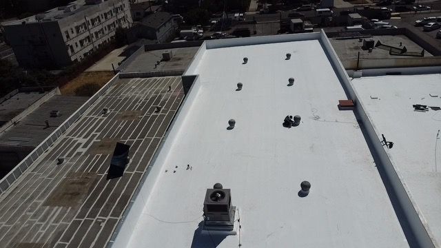 An aerial view of a building with a white roof