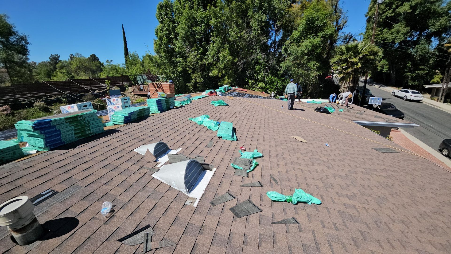 A roof with a lot of shingles on it is being repaired.