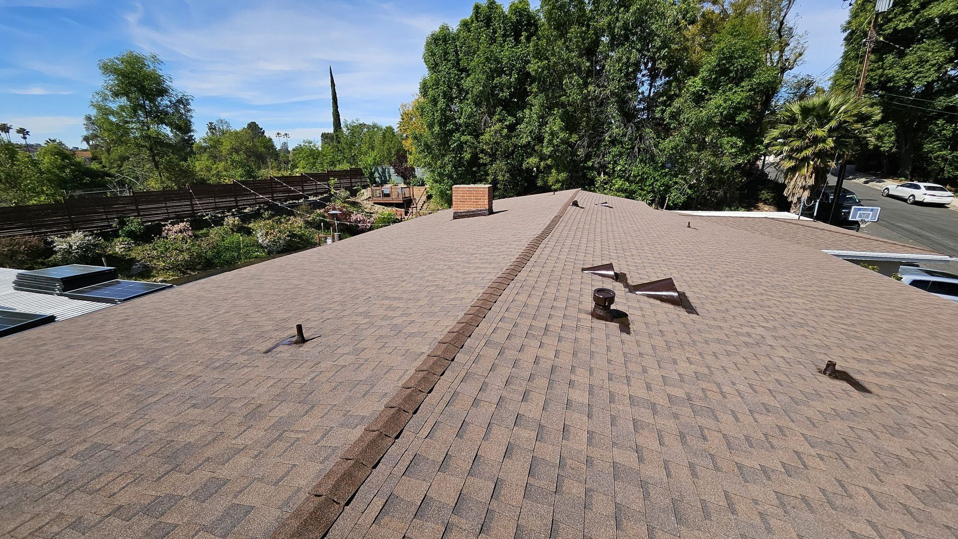 A roof with a lot of bricks on it and trees in the background