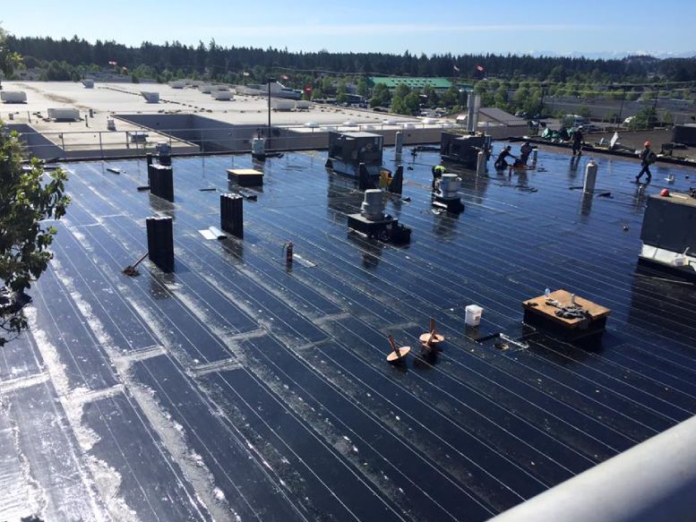 The roof of a building is being painted black