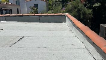 A roof with a red tile border and a gray roof.