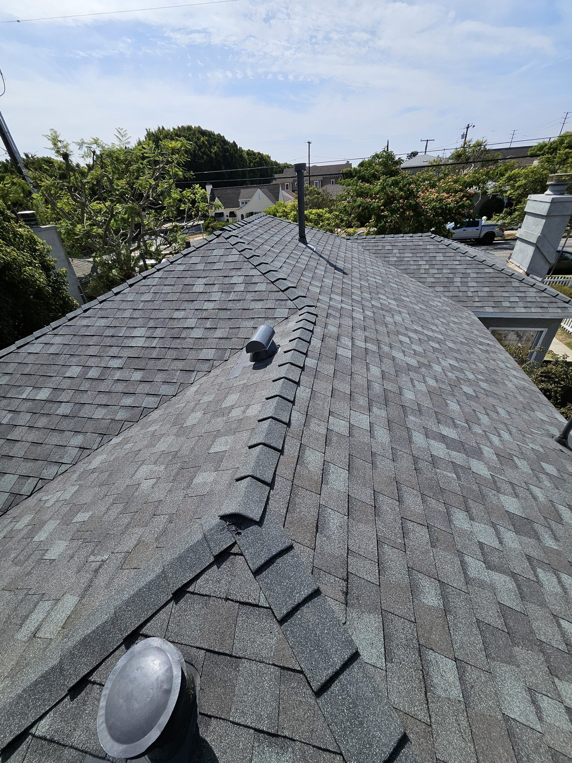 A roof with shingles and a chimney on it
