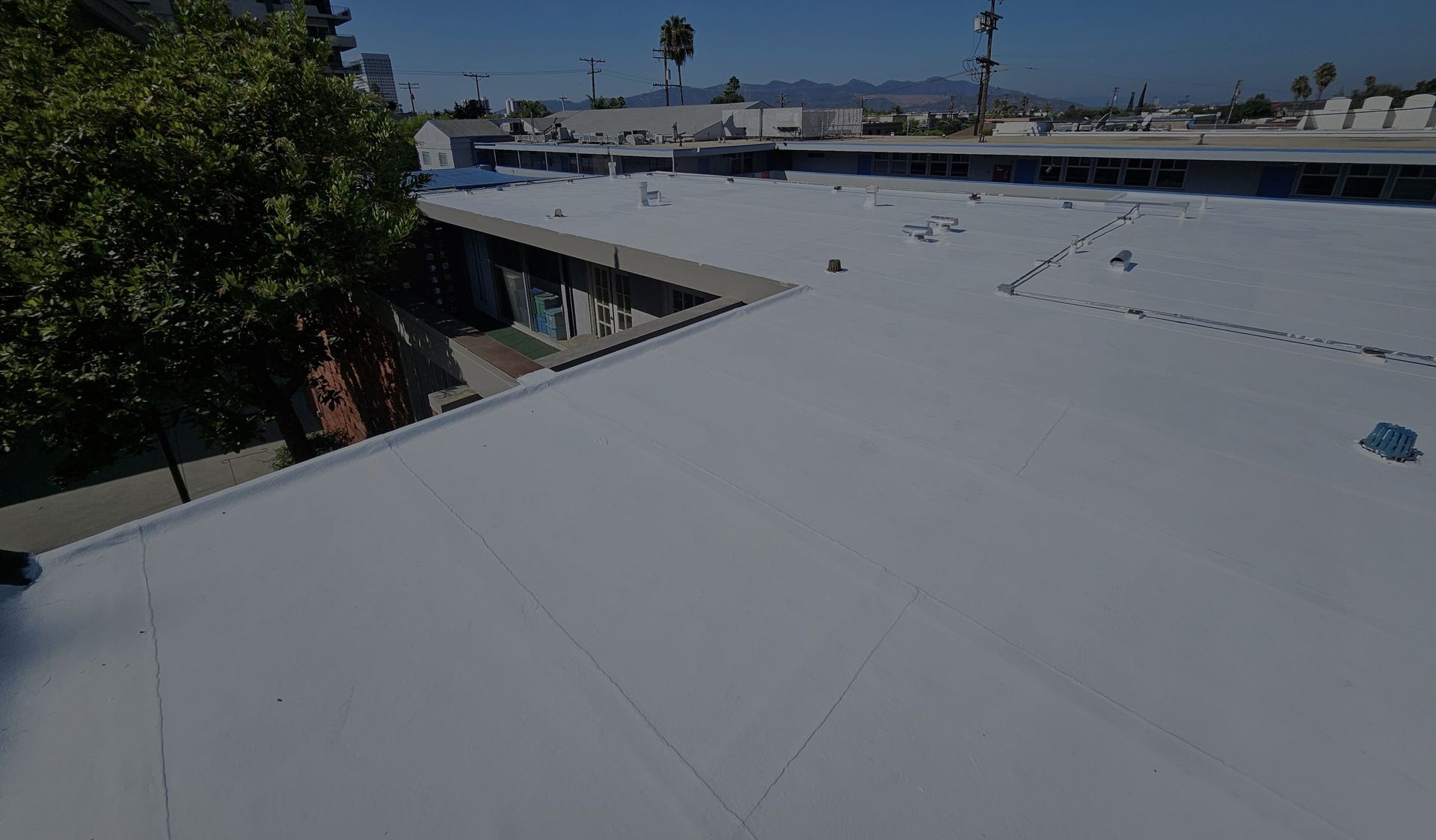 An aerial view of a building with a white roof.
