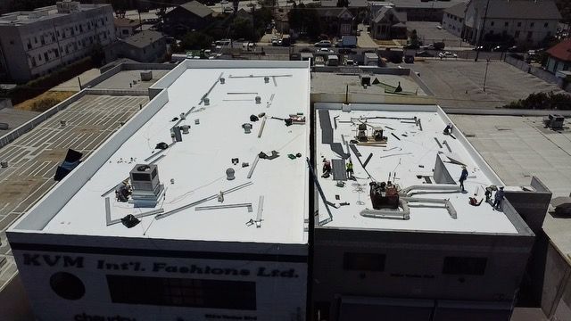 An aerial view of two buildings with a white roof